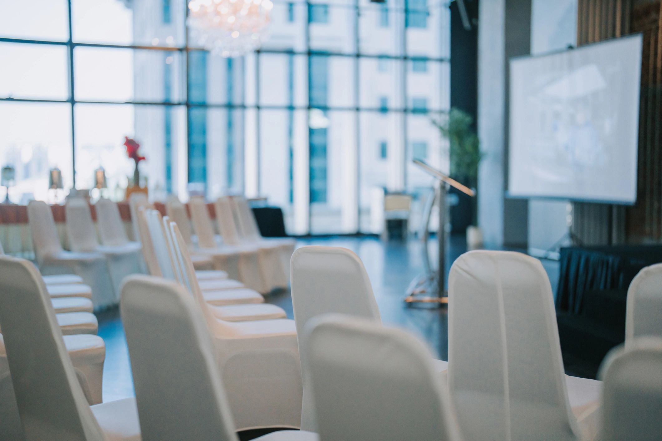 Conference room with stage, screen, and chairs ready for sessions