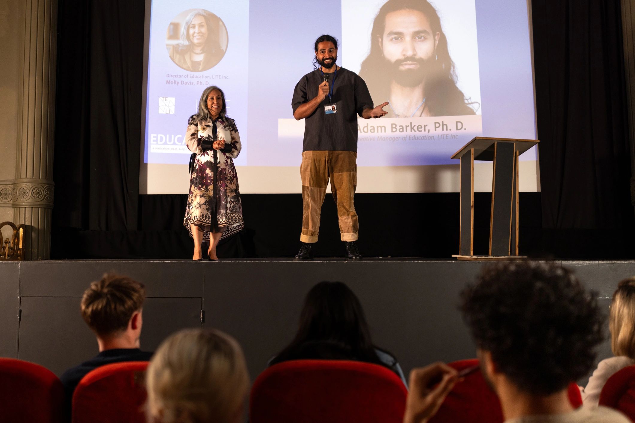 Presenters on stage during a formal conference session