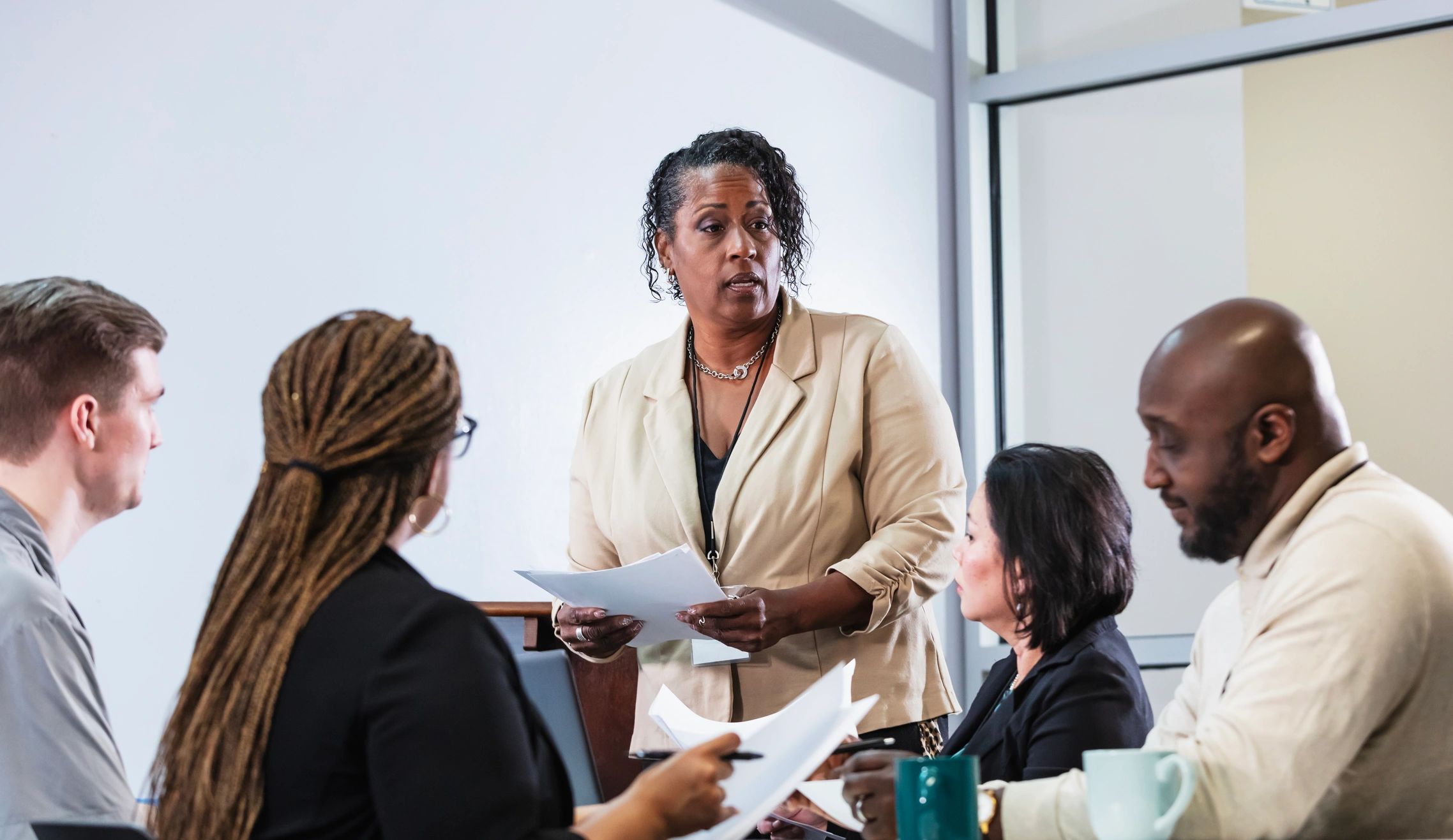 Facilitator leading a discussion with a group reviewing documents